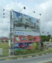 A typical billboard with a mix of Chinese, Malay, English, and Dutch
